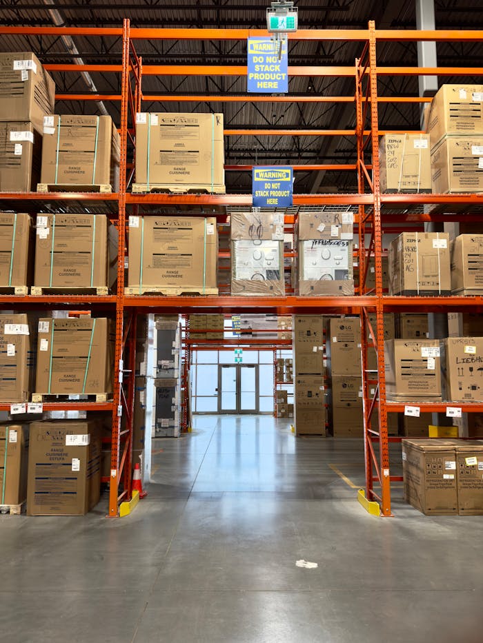 services-01 Large warehouse interior with racks filled with cardboard boxes, offering ample storage space.