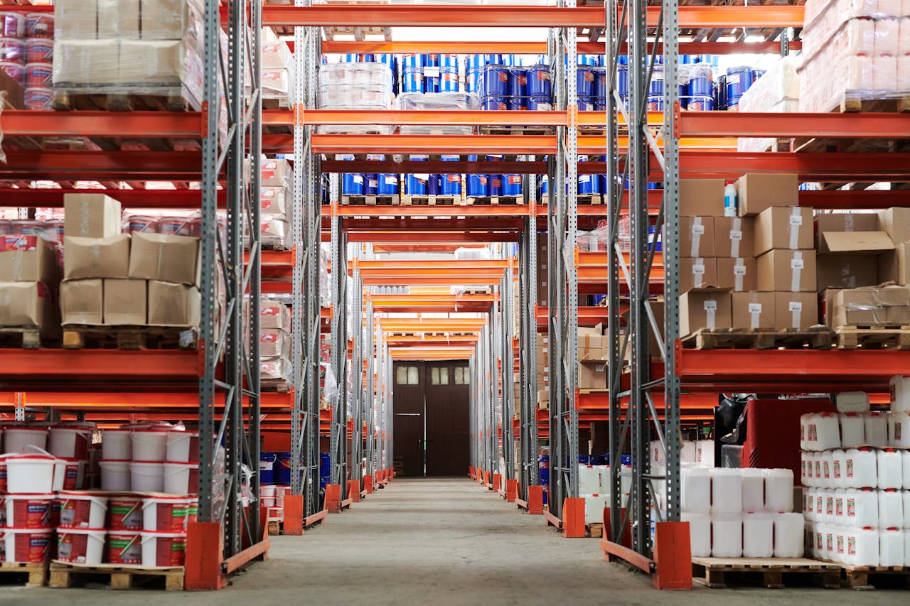 journey Wide angle view of a warehouse with stocked shelves and boxes.
